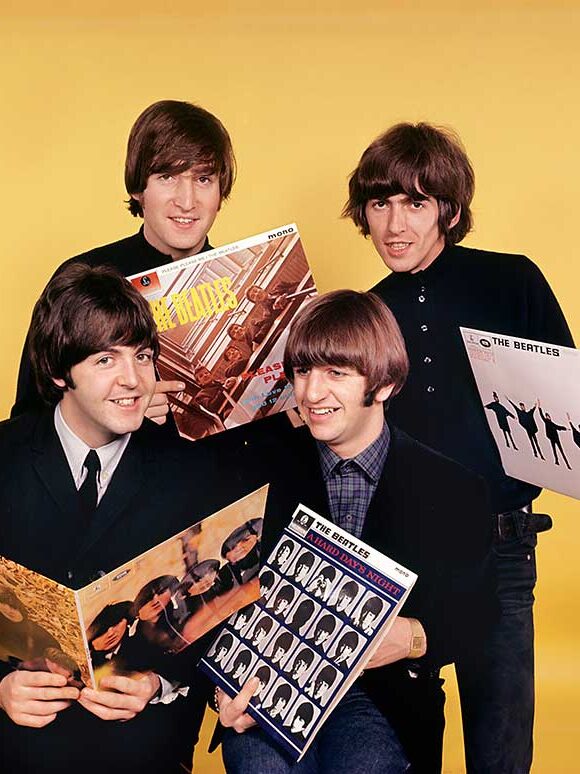 Beatles holding albums